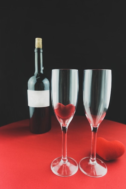 Foto gratuita bicchieri di vino con una bottiglia dietro
