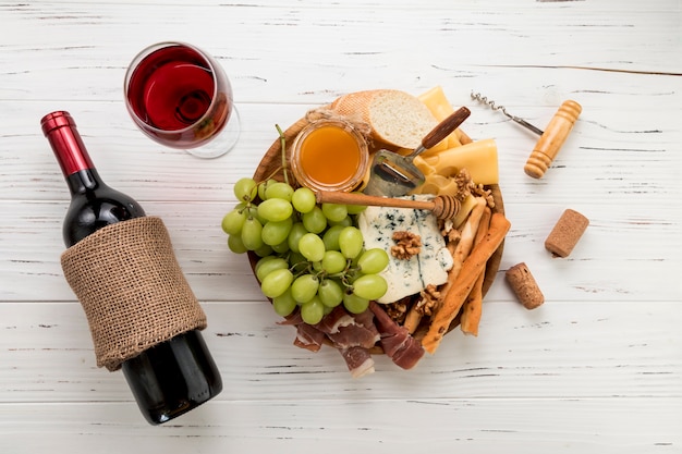 木製の背景の上に食べ物とワイン
