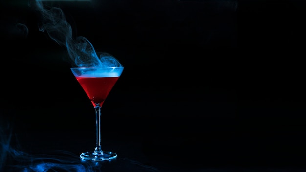 Free photo wineglass with red smoky liquid