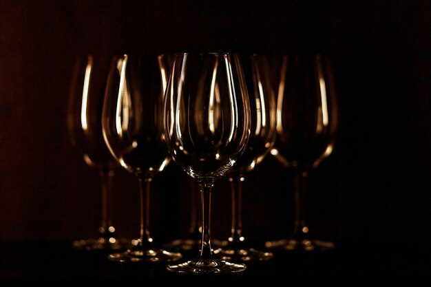 Wineglasses illuminated with warm light stand on black background