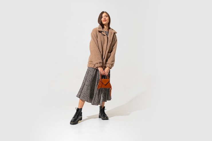 Free Photo winer fashion look. stylish brunette model in beige fur coat and. full length.