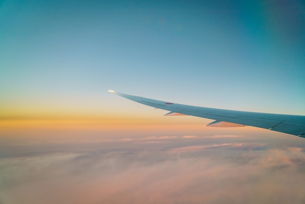 Wing of an airplane flying above the clouds