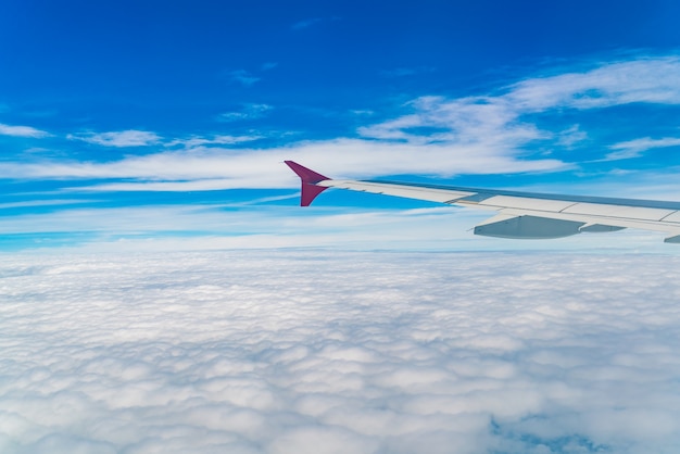 구름 위에 도착하는 비행기의 날개