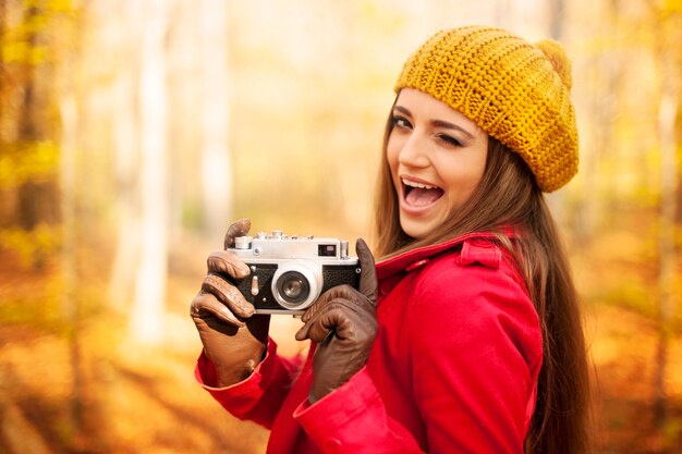 レトロなカメラで写真を撮るウインク女性