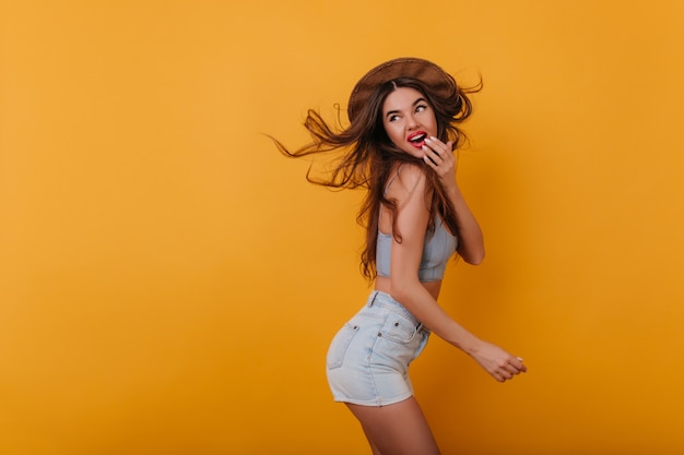 Winsome girl with excited face expression dancing on yellow space