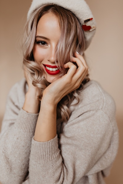 Winsome sensual woman in beret posing in studio