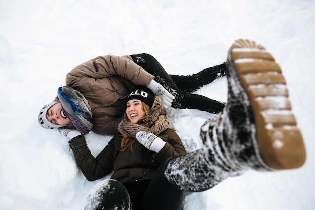 Winter. Cheerful young couple having fun in the snow. Winter love story.