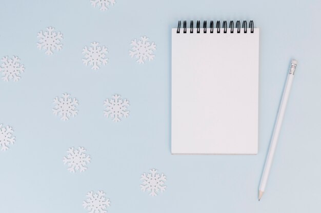 Winter composition of notepad with snowflakes 