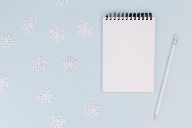 Winter composition of notepad with snowflakes 