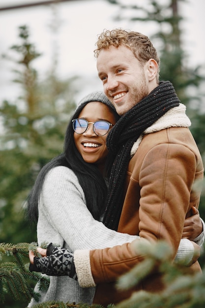 Free photo winter concept. guy in a brown coat. salesman of christmas tree. international couple.