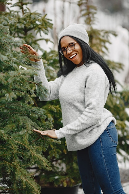 Free photo winter concept. woman in a gray sweater. saleswoman of christmas tree.