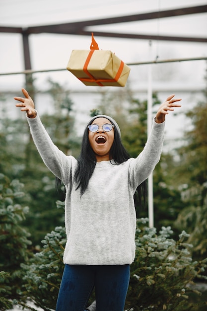 Free photo winter concept. woman in a gray sweater. saleswoman of christmas tree.