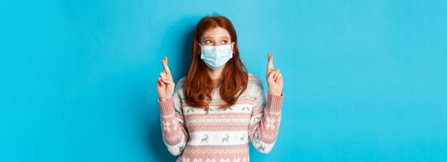 Free photo winter coronavirus and social distancing concept cute hopeful girl with red hair wearing face mask c