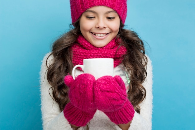 Winter dressed girl with cup in hands