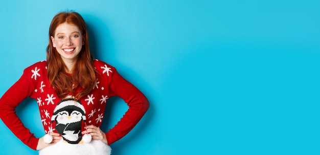 無料写真 冬の休日とクリスマスイブのコンセプト クリスマス セーターを見て美しい 10 代の赤毛の女の子