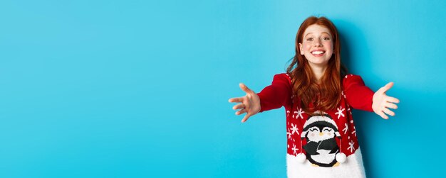 Free photo winter holidays and christmas eve concept beautiful redhead girl in xmas sweater reaching for hug ex