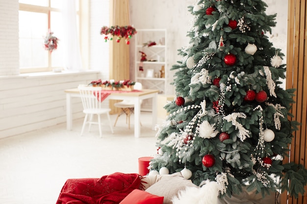 Free photo winter holidays decor. rich decorated new year tree stands with present boxes