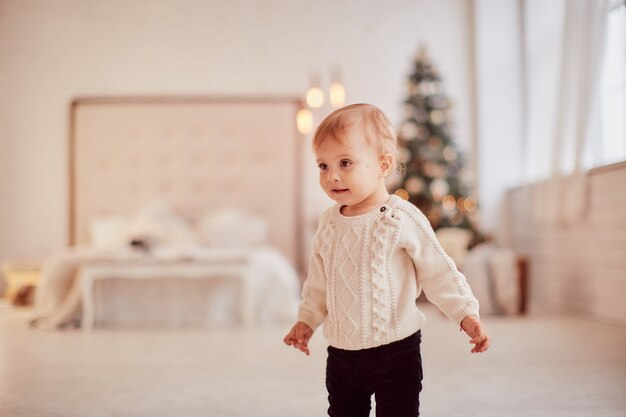 Winter holidays decorations. Warm colors. Beautiful little girl plays with present boxes