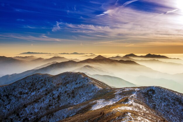 Зимний пейзаж с закатом и туманом в горах Деогюсан, Южная Корея