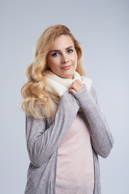 Winter portrait of Caucasian woman wrapping up in warm wool scarf 