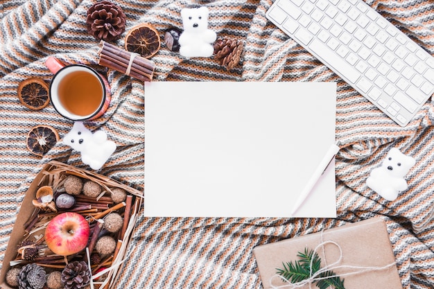 Winter symbols and gift near paper sheet and keyboard