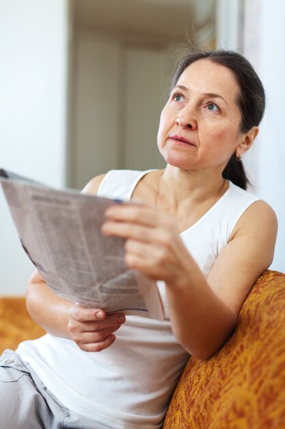  wistful  woman with newspaper  