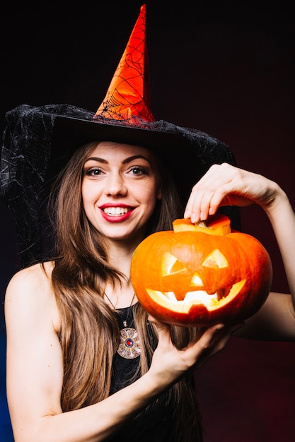 Witch girl holding pumpkin 