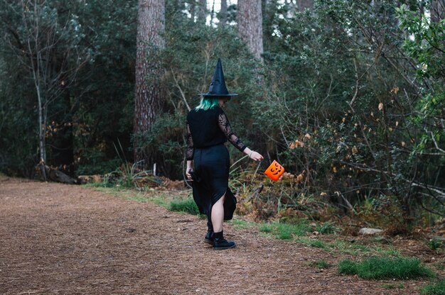 Witch girl standing back in wood