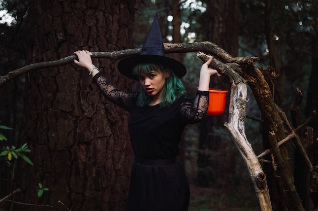 Бесплатное фото Ведьма, стоящая у ветви