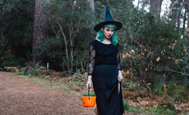 Witch with basket in forest