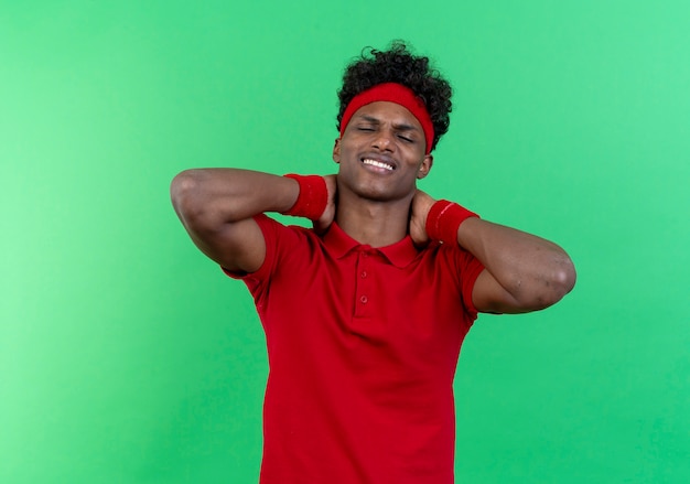 With closed eyes tired young sporty man wearing headband