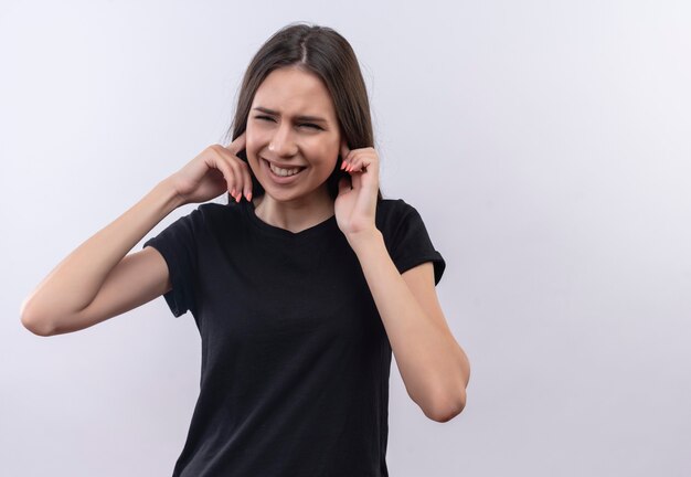 With closed eyes young caucasian girl wearing black t-shirt closed ears on isolated white