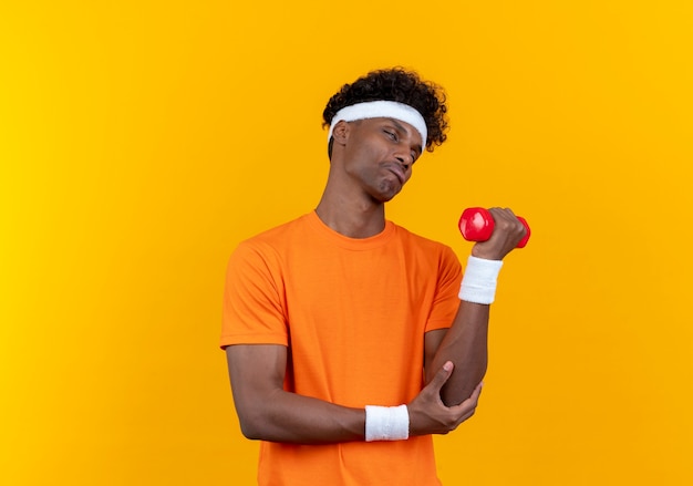 With closed eyes young confused sporty man wearing headband