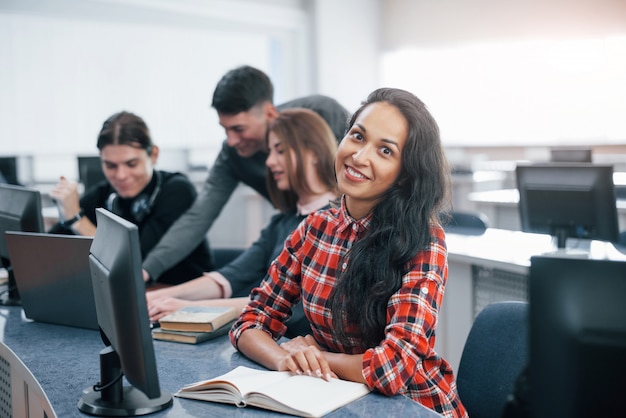 Con umore positivo. gruppo di giovani in abiti casual che lavorano nell'ufficio moderno