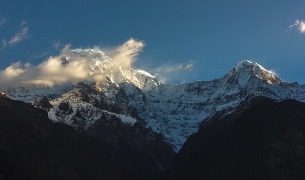 With snow on the top covered with clouds