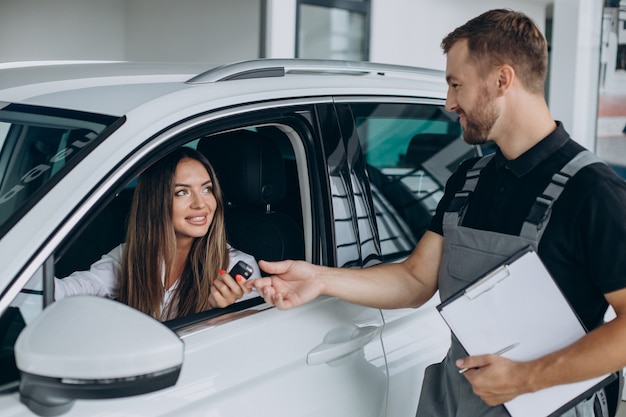 Free photo woman at acr service station checking her car with mechanic