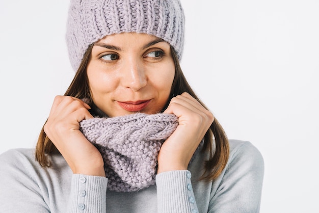 Foto gratuita donna che regola la sciarpa e distoglie lo sguardo