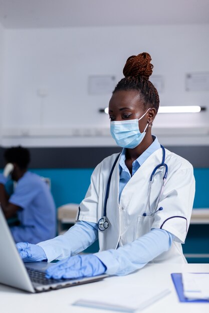 Woman of african ethnicity working as doctor in medical cabinet