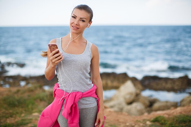 woman after fitness with phone and headphones