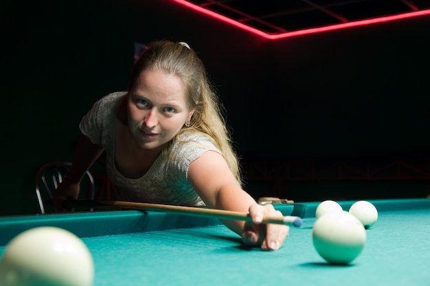 Woman aiming for billiard table