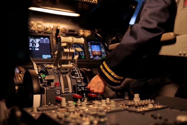 Woman airliner pushing dashboard buttons in plane cockpit, preparing to takeoff with engine lever or handle. Copilot using control panel command and windscreen navigation radar. Close up.