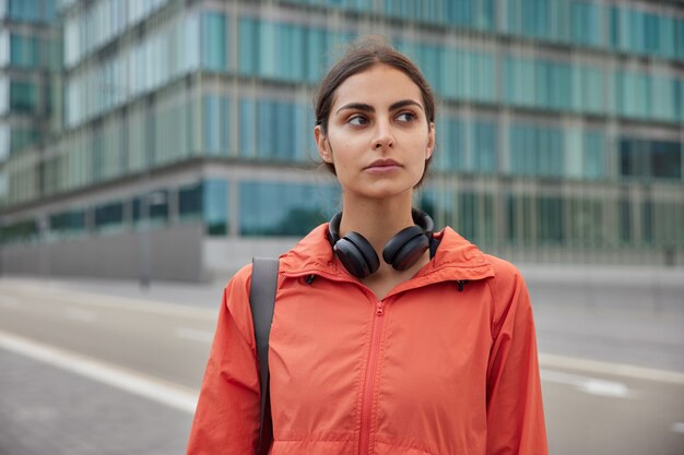  woman in anorak strolls outdoor has regular sport training to prevent negative mood and stay healthy has daily workout and exercises outdoor being active in good physical condition