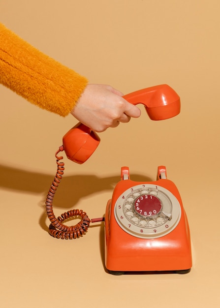 Foto gratuita donna che risponde a un vecchio telefono retrò