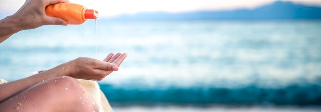 Free Photo a woman applies sunscreen on the beach copy space