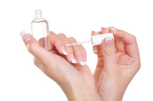 woman applying clear nail vanish on her fingernails