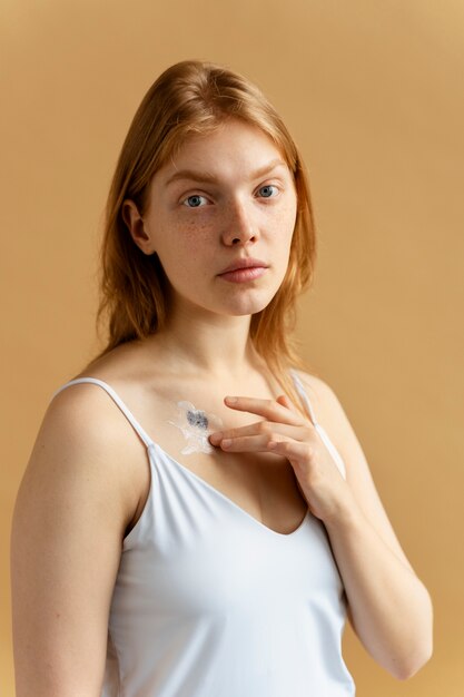 Woman applying cream on mole medium shot