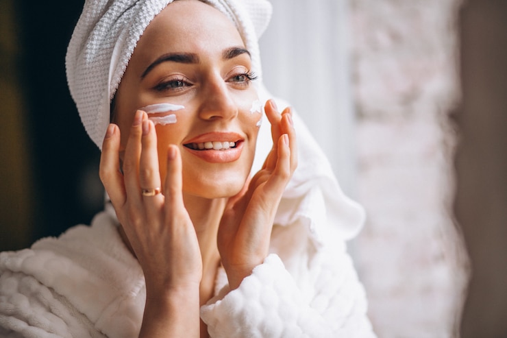 Free Photo woman applying face cream