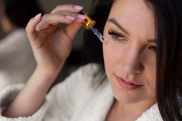 Woman applying face serum close up