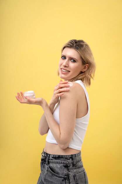 Woman applying lotion on shoulder