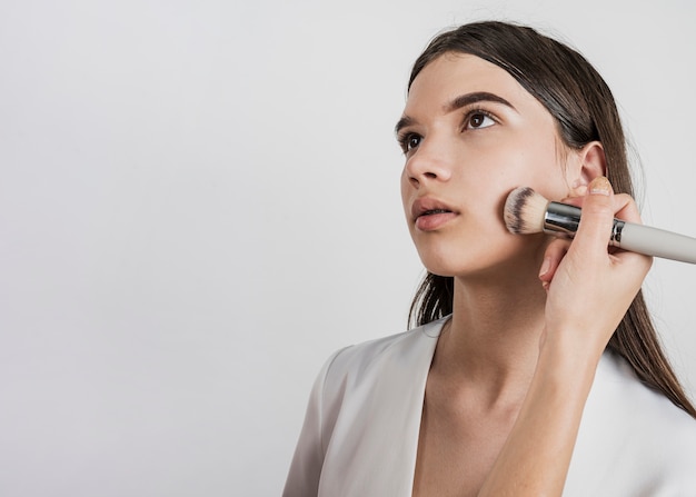 Woman applying make up on model